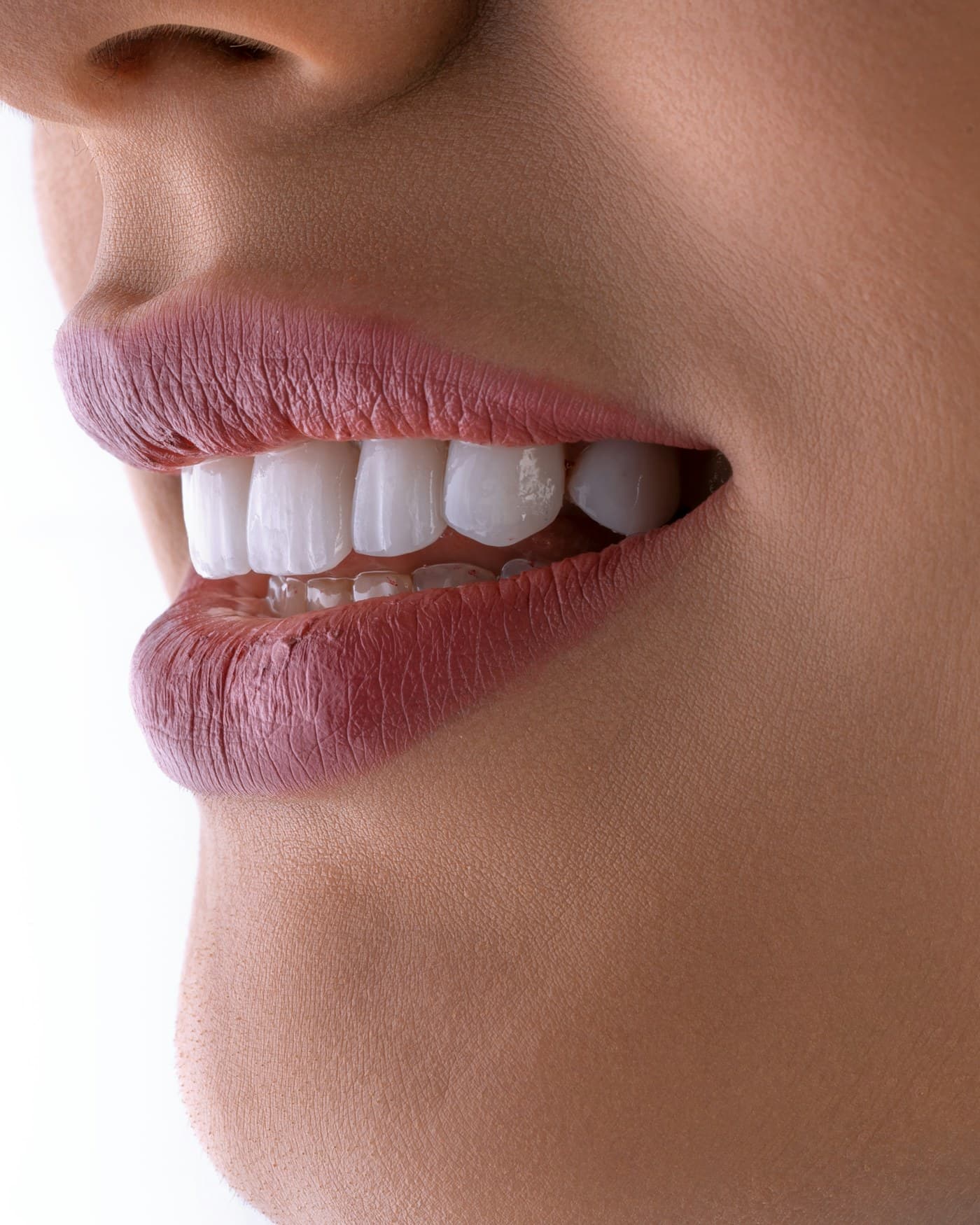 A close study of a smile in profile against a pale background.